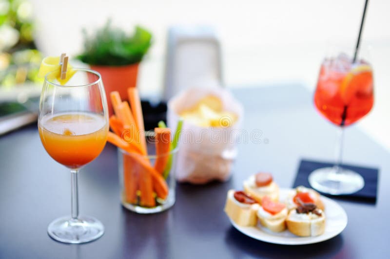 Włoscy aperitives/aperitif: dwa szkła koktajlu i zakąski półmisek na stole fotografia royalty free Włoscy aperitives/aperitif: dwa szkła koktajlu i zakąski półmisek na stole fotografia royalty free