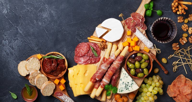 Włoskie zakąski lub antipasto ustawiający z wyśmienitym jedzeniem na czarnym stołowym odgórnym widoku Garmażeria ser i mięso prze