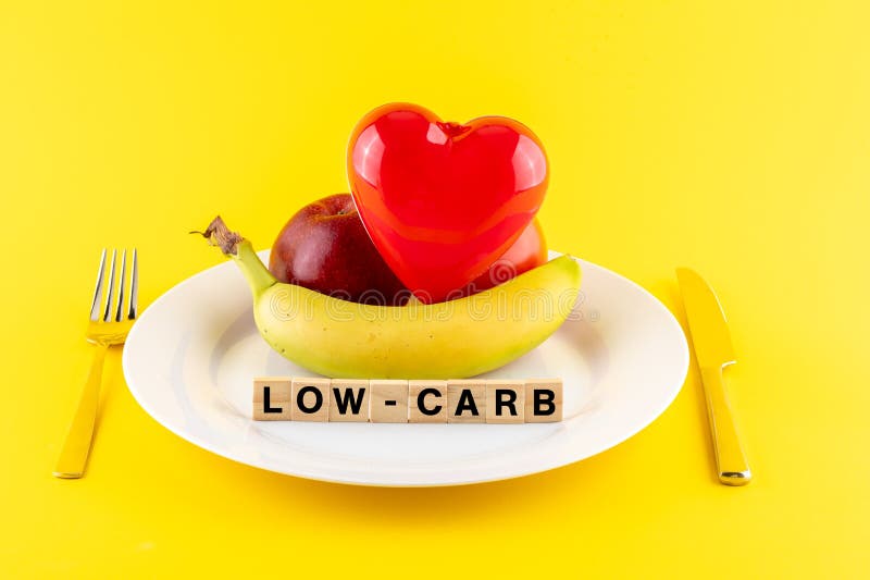 &x22;low carb&x22; words and fruits on a plate on yellow background