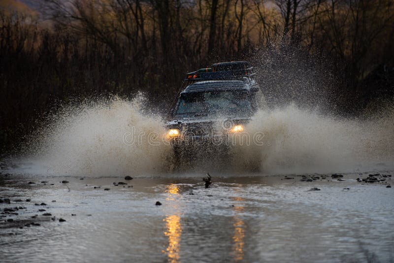4 x 4 reserekittering Krockade i en puddle och plockade upp en sprej av smuts Utomhusäventyr vacker Bästa royaltyfri bild