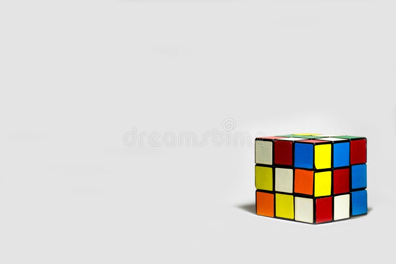 A 3x3 Rubik`s cube placed diagonally on a plain white background. The photograph has empty space for text.