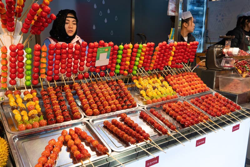 Xian, China - Feb 20, 2018: Tanghulu traditional Chinese dessert candied fruit on a wooden stick at Muslim Quarter, street, Xi`an