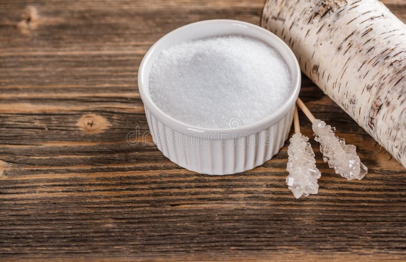 Xylitol in white bowl with candy sugar sticks. Xylitol in white bowl with candy sugar sticks