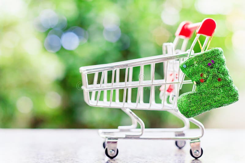 Xmas blänker kängan med den mini- den shoppingvagnen eller spårvagnen mot blått arkivbild Xmas blänker kängan med den mini- den shoppingvagnen eller spårvagnen mot blått arkivbild