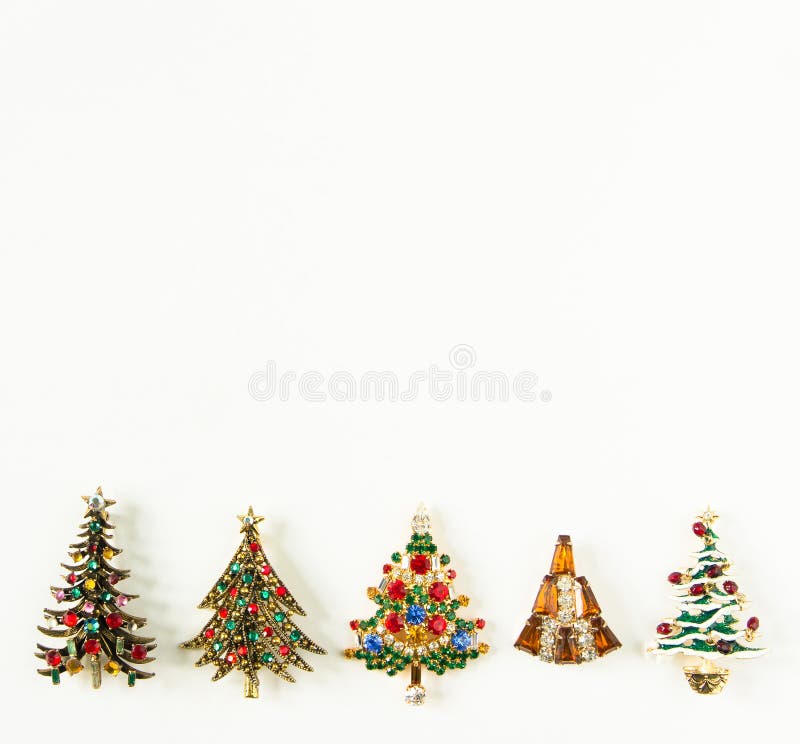 Xmas theme. Woman Jewelry. Vintage jewelry background. Beautiful bright rhinestone christmas tree brooches on white background. royalty free stock image Xmas theme. Woman Jewelry. Vintage jewelry background. Beautiful bright rhinestone christmas tree brooches on white background. royalty free stock image