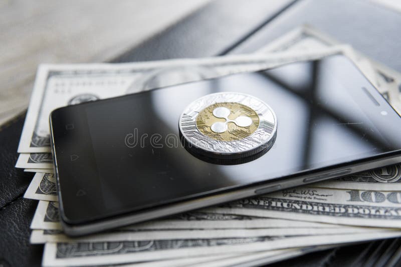 Xrp cripto da ondinha da moeda no smartphone e em fundo do dinheiro dos dólares americanos Blockchain e moeda do cyber Dinheiro g imagem de stock Xrp cripto da ondinha da moeda no smartphone e em fundo do dinheiro dos dólares americanos Blockchain e moeda do cyber Dinheiro g imagem de stock