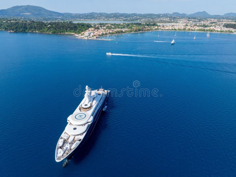 Yacht de luxe dans les eaux claires bleu près de la ville côtière images stock