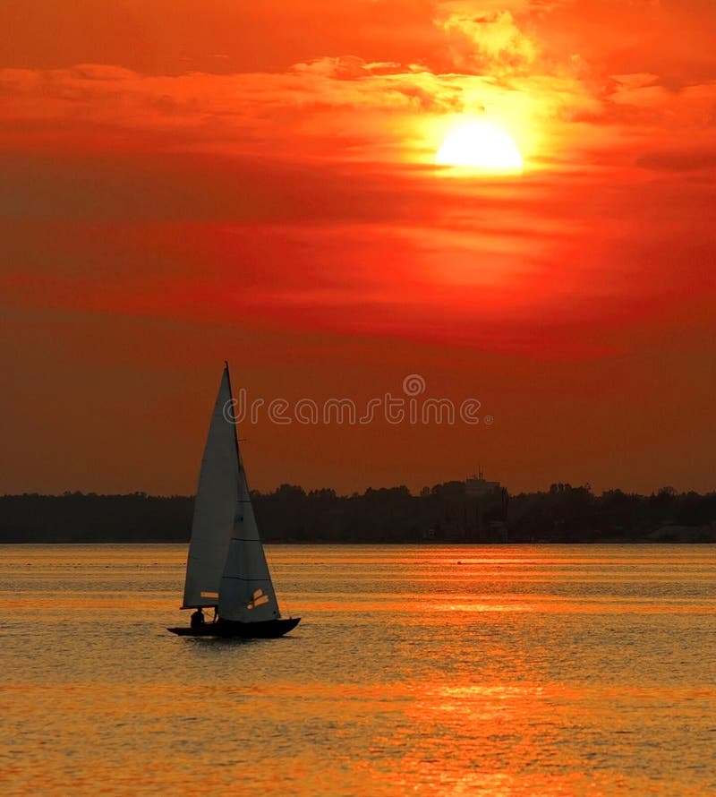 Yacht sailing into sunset