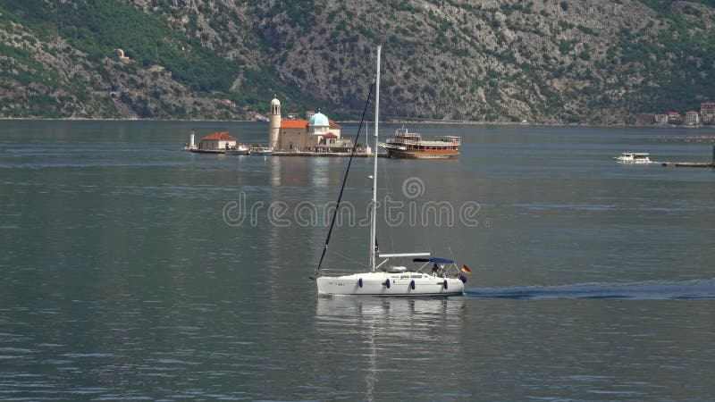 Yacht som färdas nära öar i kotorbukten