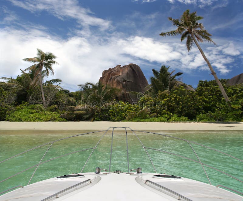 The luxury yacht arrived to the tropical island. Paradise beach is in-front and surrounded by palm-trees , rocks and quite water of sea. La' Digue island , Seychelles. The luxury yacht arrived to the tropical island. Paradise beach is in-front and surrounded by palm-trees , rocks and quite water of sea. La' Digue island , Seychelles.