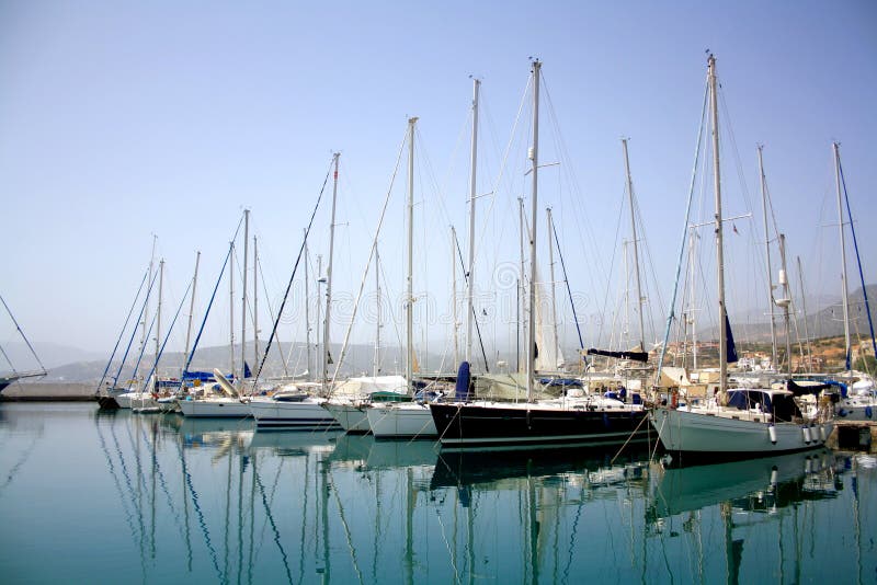 Yachtparken im Hafen, Hafenyachtclub in Agios Nikolaos, Kreta, Griechenland Schöne Yachten im Hintergrund des blauen Himmels lizenzfreies stockbild Yachtparken im Hafen, Hafenyachtclub in Agios Nikolaos, Kreta, Griechenland Schöne Yachten im Hintergrund des blauen Himmels lizenzfreies stockbild