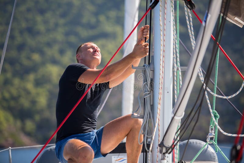 Yachtsman Pulls the Rope Controlling the Sail on Sailing Boat. Sport