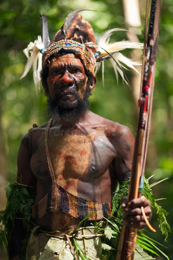 NEW GUINEA, INDONESIA - 2 FEBRUARY: The warrior of a Papuan tribe of Yafi in traditional clothes, ornaments and coloring. New Guinea Island, Indonesia. February 2, 2009. NEW GUINEA, INDONESIA - 2 FEBRUARY: The warrior of a Papuan tribe of Yafi in traditional clothes, ornaments and coloring. New Guinea Island, Indonesia. February 2, 2009.