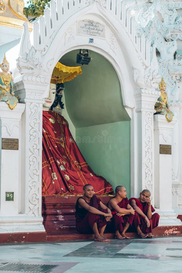 Yangon, το Μιανμάρ - 19 Φεβρουαρίου 2014: Οι μοναχοί κάθονται μπροστά από το τ στοκ εικόνες Yangon, το Μιανμάρ - 19 Φεβρουαρίου 2014: Οι μοναχοί κάθονται μπροστά από το τ στοκ εικόνες