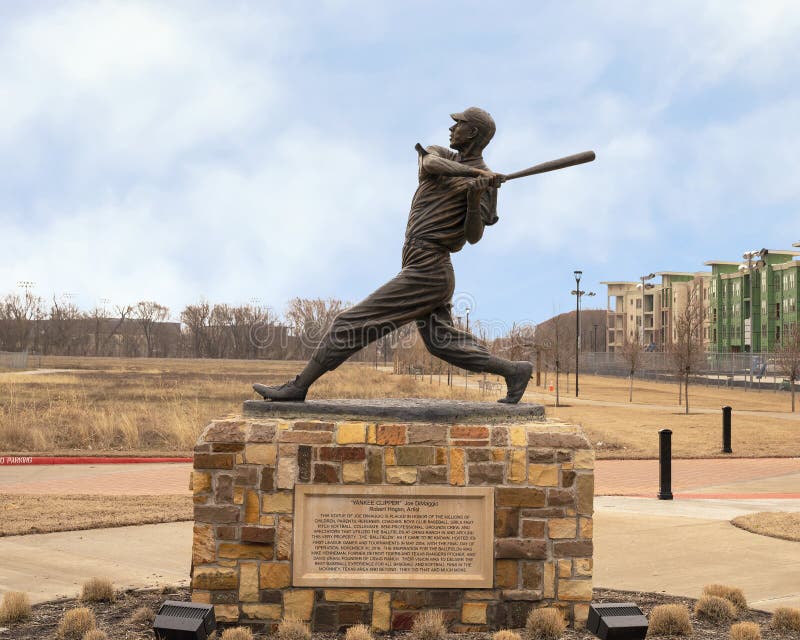 Pictured is a bronze sculpture of Joe DiMaggio titled `The Yankee Clipper` by Robert Hogan in McKinney, Texas.  The famous New York Yankees slugger is in motion at the plate, probably hitting another home run.  It was created in 2004 and is part of the public art collection of the City of McKinney.