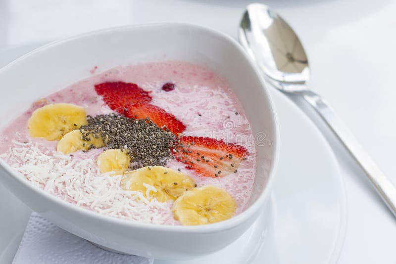 Yaourt avec la fraise de banane et chia dans le plat en céramique blanc avec les nappes blanches photo libre de droits Yaourt avec la fraise de banane et chia dans le plat en céramique blanc avec les nappes blanches photo libre de droits