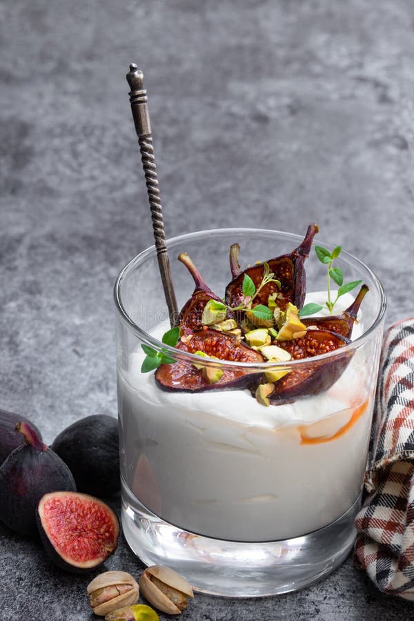 Yaourt fait maison avec les figues et la pistache grillées sur la table grise image libre de droits Yaourt fait maison avec les figues et la pistache grillées sur la table grise image libre de droits