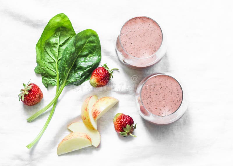 Yaourt probiotic de noix de coco, épinards, pomme, smoothie de detox de fraise sur un fond clair, vue supérieure Concept de nourr photos stock Yaourt probiotic de noix de coco, épinards, pomme, smoothie de detox de fraise sur un fond clair, vue supérieure Concept de nourr photos stock