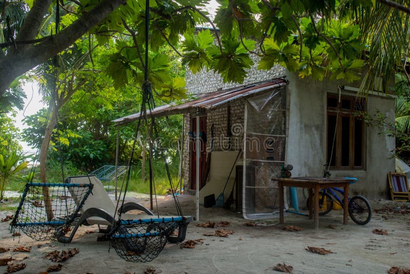 Yard with house, bicycle, table and chairs at the tropical island