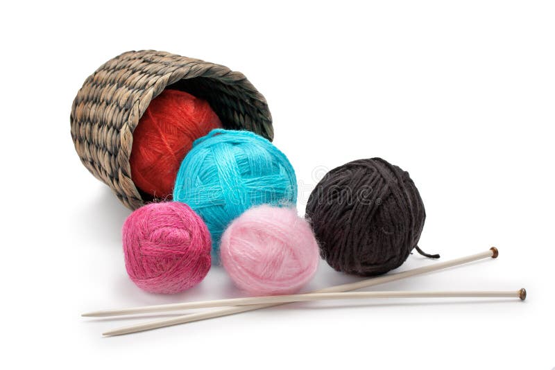 Yarn and knitting needles arranged in a basket isolated on white background