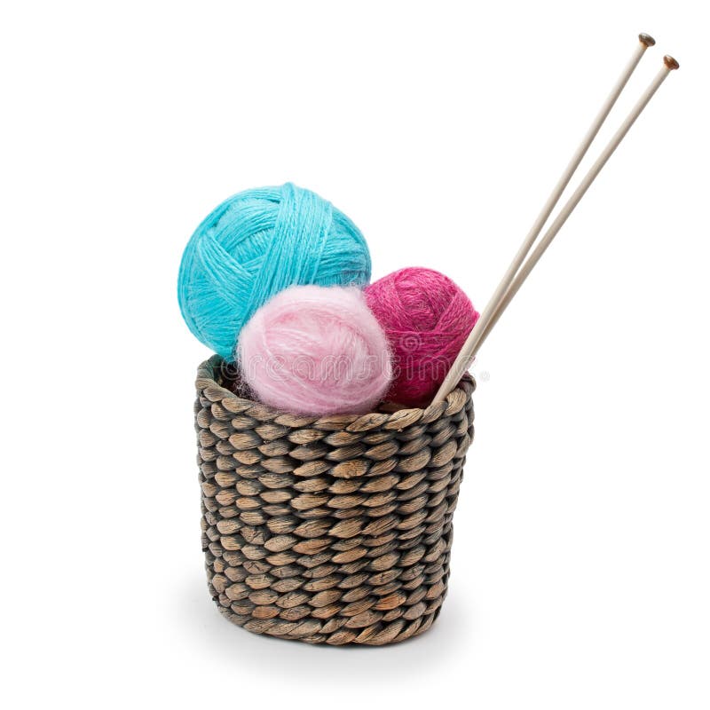 Yarn and knitting needles arranged in a basket isolated on white background