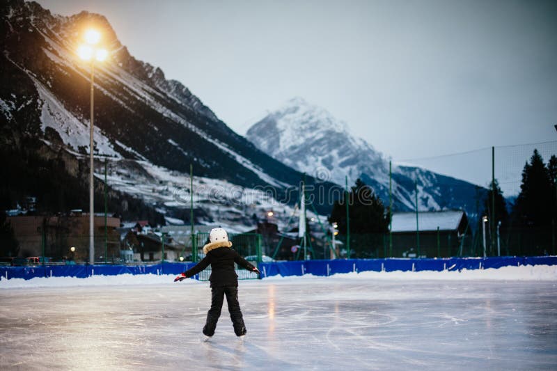 9 year old girl skates on the ice in the evening on an illuminated track royalty free stock photography 9 year old girl skates on the ice in the evening on an illuminated track royalty free stock photography