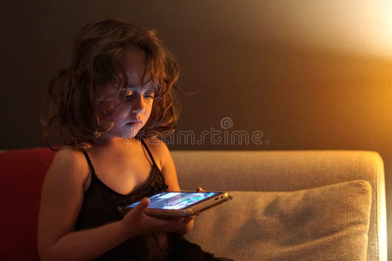 3-4 year old girl uses cell phone at night