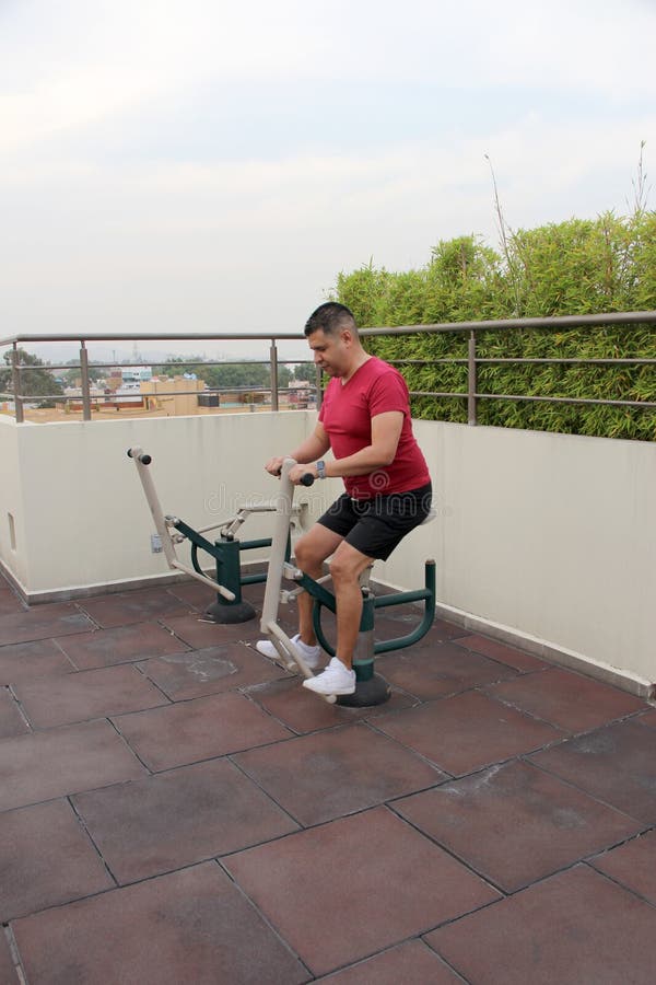 40 year old Man Exercises On The Roof Garden Of His Building With 40-year-old-man-exercises-on-the-roof-garden-of-his-building-with