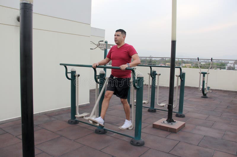 40 year old Man Exercises On The Roof Garden Of His Building With 40-year-old-man-exercises-on-the-roof-garden-of-his-building-with