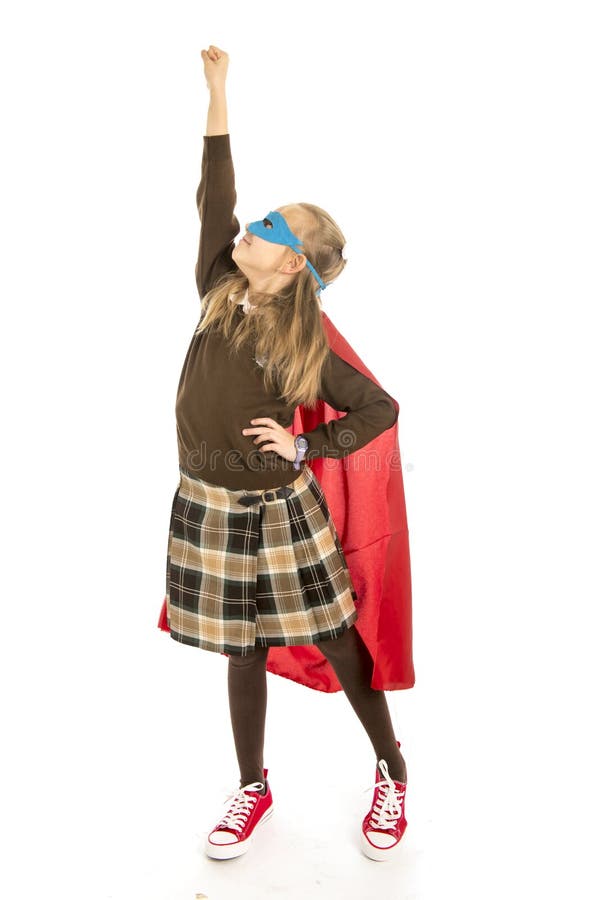 7 or 8 years old young female child in super hero costume over school uniform performing happy and excited isolated on white back