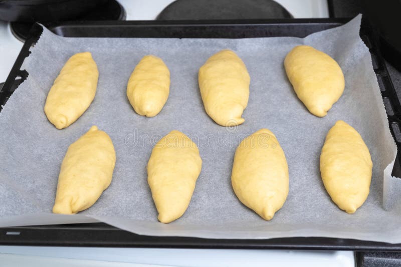 Yeast dough pies on a baking sheet. Raw pies. Photo. Raw fresh yeast dough stock images, royalty-free photos and pictures