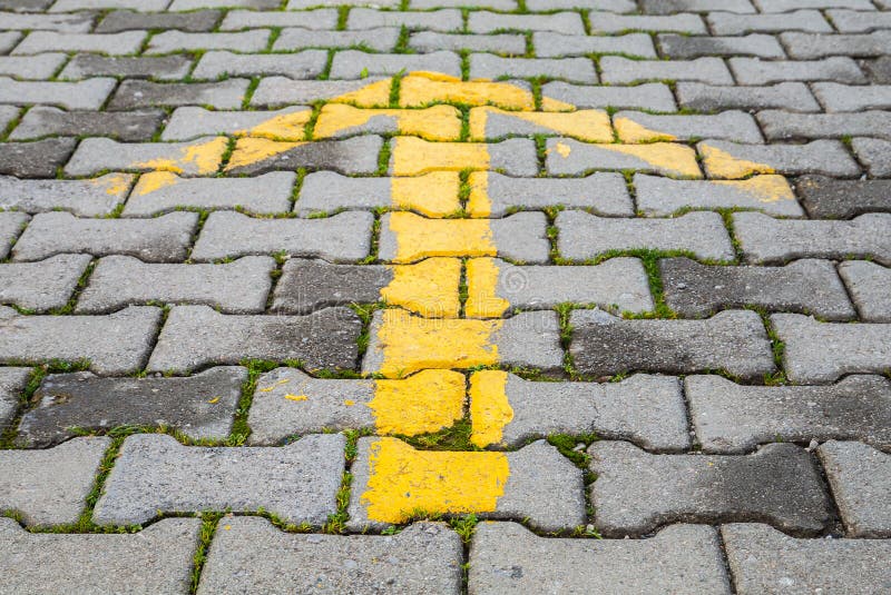 Yellow Arrow Painted on Gray Pavement, Road Direction Sign Stock Image