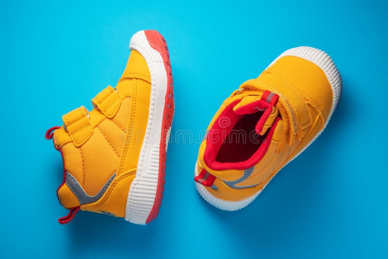 Yellow Baby Shoes. Kids Sport Sneakers Isolated on Blue Background ...
