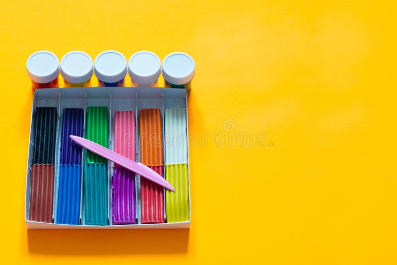 On a Yellow Background Lies a Box with Plasticine and Paint Stock Image