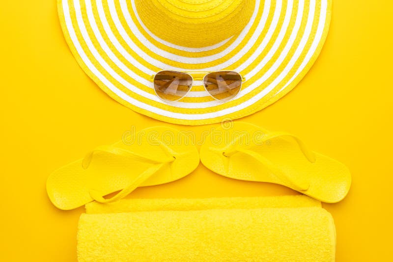 Beach accessories on the yellow background - sunglasses, towel. flip-flops and striped hat. summer is coming concept royalty free stock photos Beach accessories on the yellow background - sunglasses, towel. flip-flops and striped hat. summer is coming concept royalty free stock photos