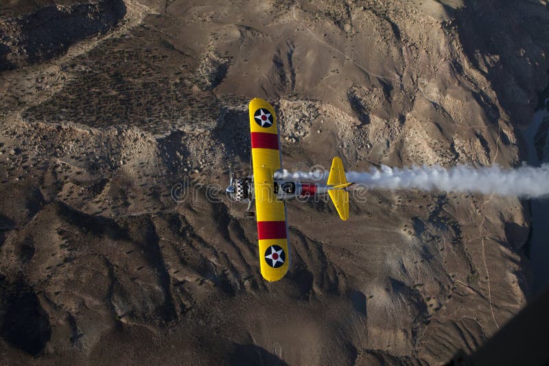 Yellow biplane over desert