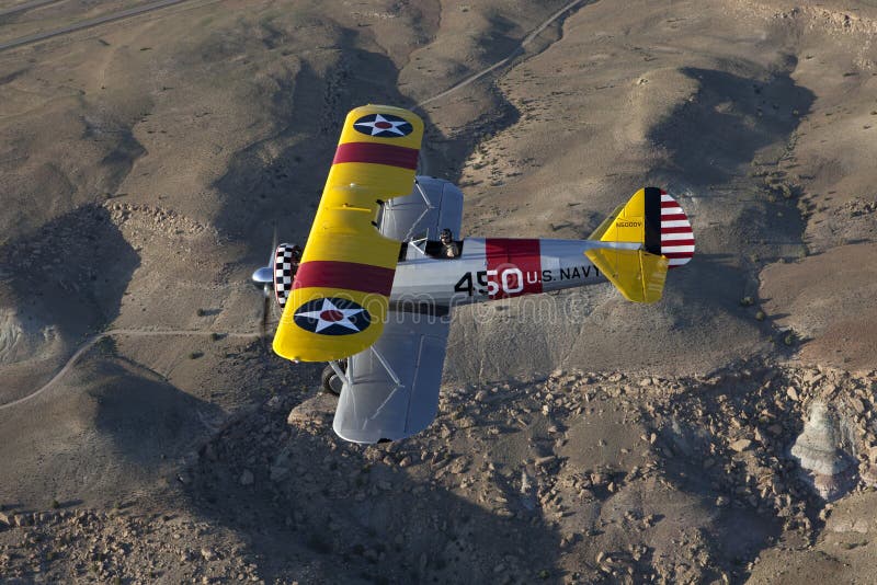 Yellow biplane over desert