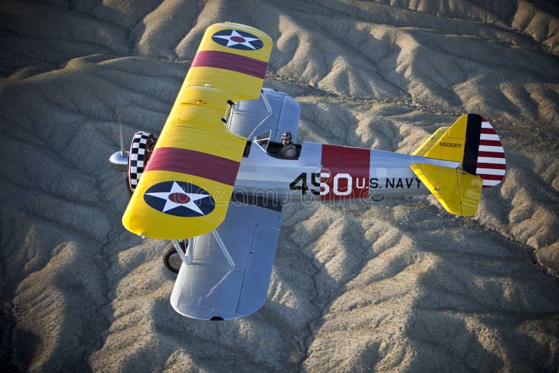 Yellow biplane over desert