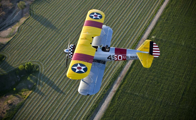 Yellow biplane over field