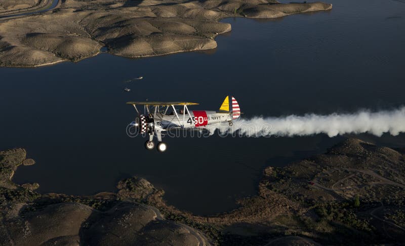 Yellow biplane over lake