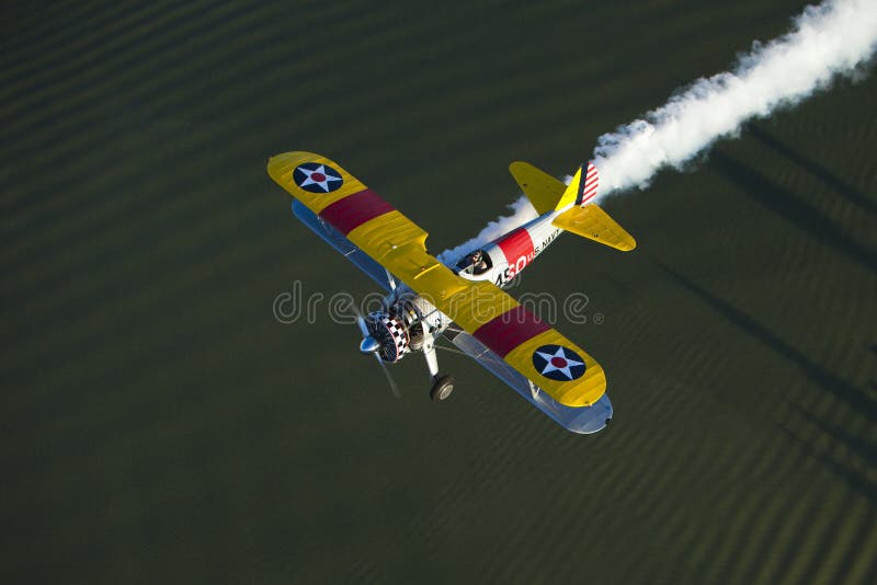 Yellow biplane over lake