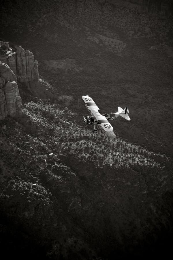 Yellow biplane over large canyon