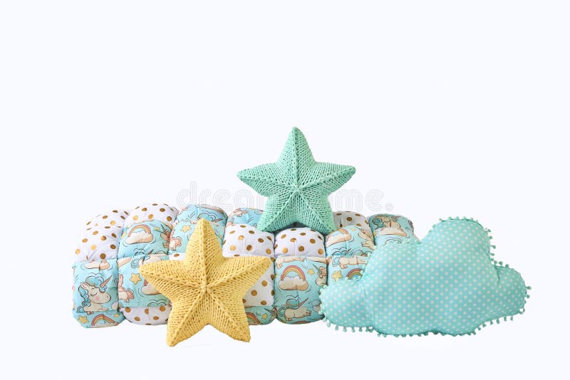 Yellow and blue-green knitted five-pointed star shaped pillows, patchwork comforter and cloud shaped blue pillow on white backgrou