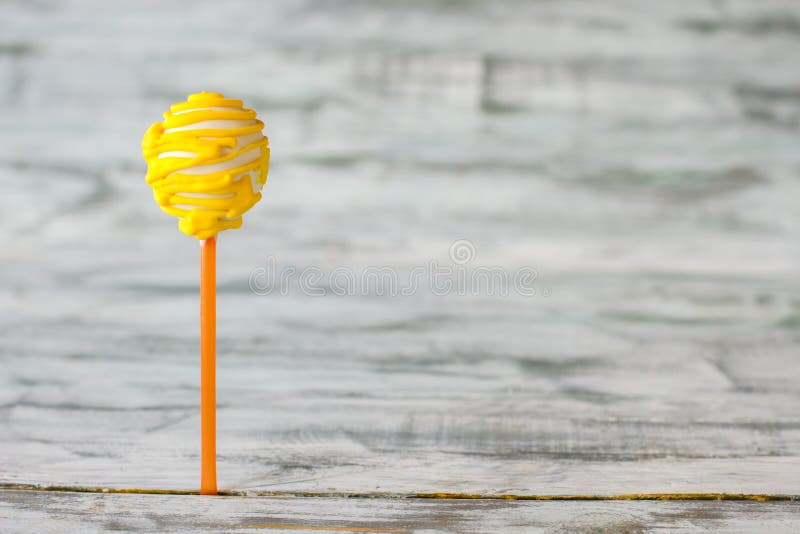 Yellow candy on stick.