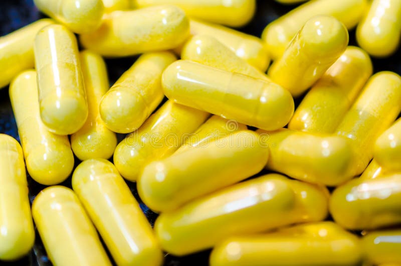 Yellow drug capsules macro stock image. Image of capsules 46996835