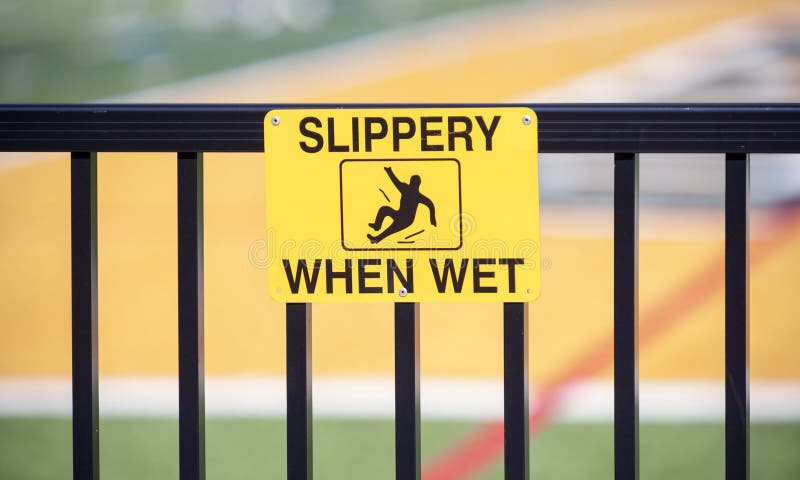 Yellow caution sign warns surface is `Slippery When Wet` stock images Yellow caution sign warns surface is `Slippery When Wet` stock images