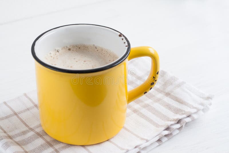 Yellow Cup of Cappuccino Coffee on a Background in Tone Stock Photo