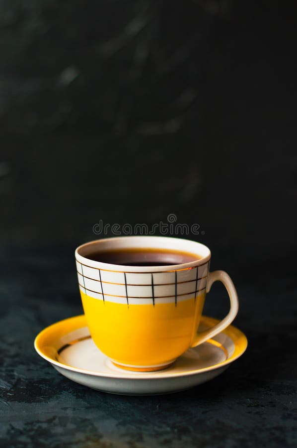 A Yellow Cup of Tea or Coffee without Foam, Closeup on a Yellow