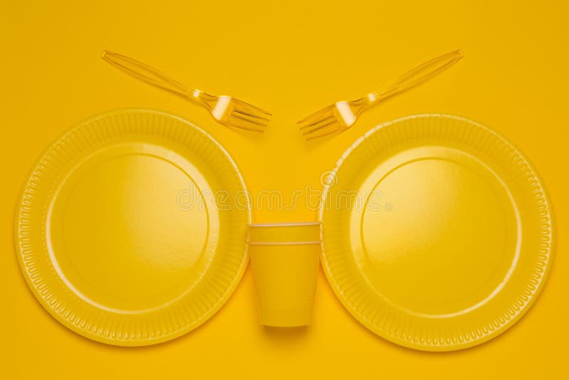 Yellow Disposable Tableware on a Yellow Background, Two Plates, Two
