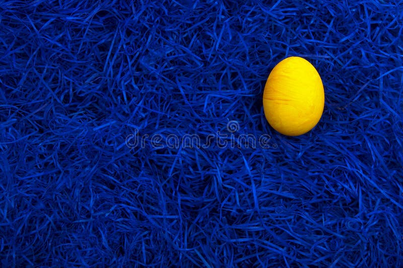 Yellow easter egg on dark blue